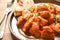 Plate of delicious butter chicken on wooden table, closeup.