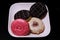 Plate of delicious freshly baked donuts of different flavors