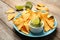 Plate with delicious mexican nachos chips, guacamole sauce and lime