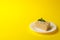 Plate with delicious Napoleon cake on yellow background