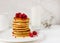 Plate with delicious pancakes with raspberries and honey on white background.