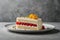 Plate with delicious raspberry cake on grey table, closeup