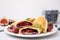 Plate of delicious samosas, berries and mint leaves on white table