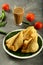 Plate of delicious vegan snack samosa, tea