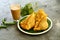 Plate of delicious vegan snack samosa, tea