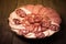 Plate with different sliced sausage on an old wooden table