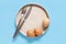 Plate, eggs, fork and knife over light blue background