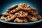 Plate filled with an cookies, complete with generous chunks of rich chocolate, is on a blue background.