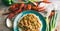 Plate filled with crawfish etouffee and rice. Shown with whole boiled crawfish and green onions on a wood background.