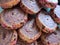 Plate filled with shortcrust cookies. with spiral pattern, decorated with pink colored seeds on the sides.