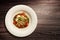 Plate of fish on vegetables served on wooden background