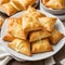 Plate of flaky puff pastries filled with soft and creamy cheeses