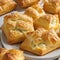 Plate of flaky puff pastries filled with soft and creamy cheeses