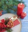 Plate, fork, knife, candle, place december christmas branch of a Christmas tree on a blue wooden background
