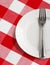Plate and fork on table with checked tablecloth