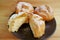 Plate of French Cream Puffs Filled with Custard Cream or Choux a la Creme Pastries Served on Wooden Table