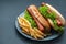 Plate with french fries and hot dogs on table