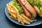 Plate with french fries and hot dogs on table, closeup