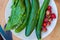 Plate of fresh cucumber, spinach and strawberries, view from above, placed on a old outdoor table