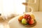 Plate with fresh fruits on beige color single sofa chair in living room.Close up