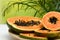 Plate with fresh juicy cut papayas on white table against blurred background