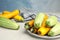 Plate with fresh ripe zucchinis on light table against blue background