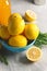 Plate of fresh sliced lemons, rosemary, bottle with lemon drink