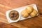 Plate of freshly-baked bread rolls and a serving of savory soup topped with succulent pieces of meat