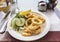 Plate of fried calamari (squid rings) with salad garnish