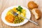 Plate with fried potato, squash caviar, green peas, fork, broken bread on table