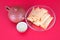 A plate of fried spring rolls and teapots and bowls on a red background