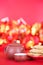 A plate of fried spring rolls and teapots and bowls on a red festive background