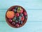 Plate, fruit berries, cherry, strawberry, blueberry summer dessert on a blue wooden background