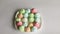 A plate full of colorful meringue cookies on a white background.