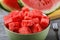 Plate full of pieces of ripe watermelon on a wooden table