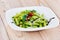 A plate of green penne pasta with broccoli on table