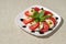 Plate of healthy classic delicious caprese on a white plate on a light linen tablecloth clear space
