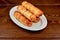 A plate of hot dogs sitting on top of a wooden table