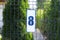 Plate with house number eight hanging on iron fence outdoors