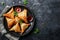 Plate with indian samosas on black stone background. Generative AI