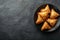 Plate with indian samosas on black stone background. Generative AI