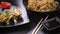 Plate with Japanese gyozo dumplings on the table. Asian food on a dark background of fried dumplings and udon noodles