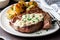 plate of juicy steak, drizzled with creamy garlic sauce and served alongside perfectly seasoned potatoes
