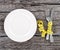 Plate with a knife and fork wrapped in measuring tape on a wooden