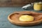 Plate and knife with Ghee butter on light blue wooden table, closeup