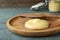 Plate and knife with Ghee butter on light blue wooden table, closeup