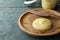 Plate and knife with Ghee butter on light blue wooden table, closeup. Space for text