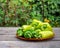 Plate with large green peppers on a wooden unpainted table in a r garden