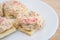 Plate of lobster dip on saltine crackers on wood table