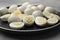 Plate with many peeled hard boiled quail eggs on grey table